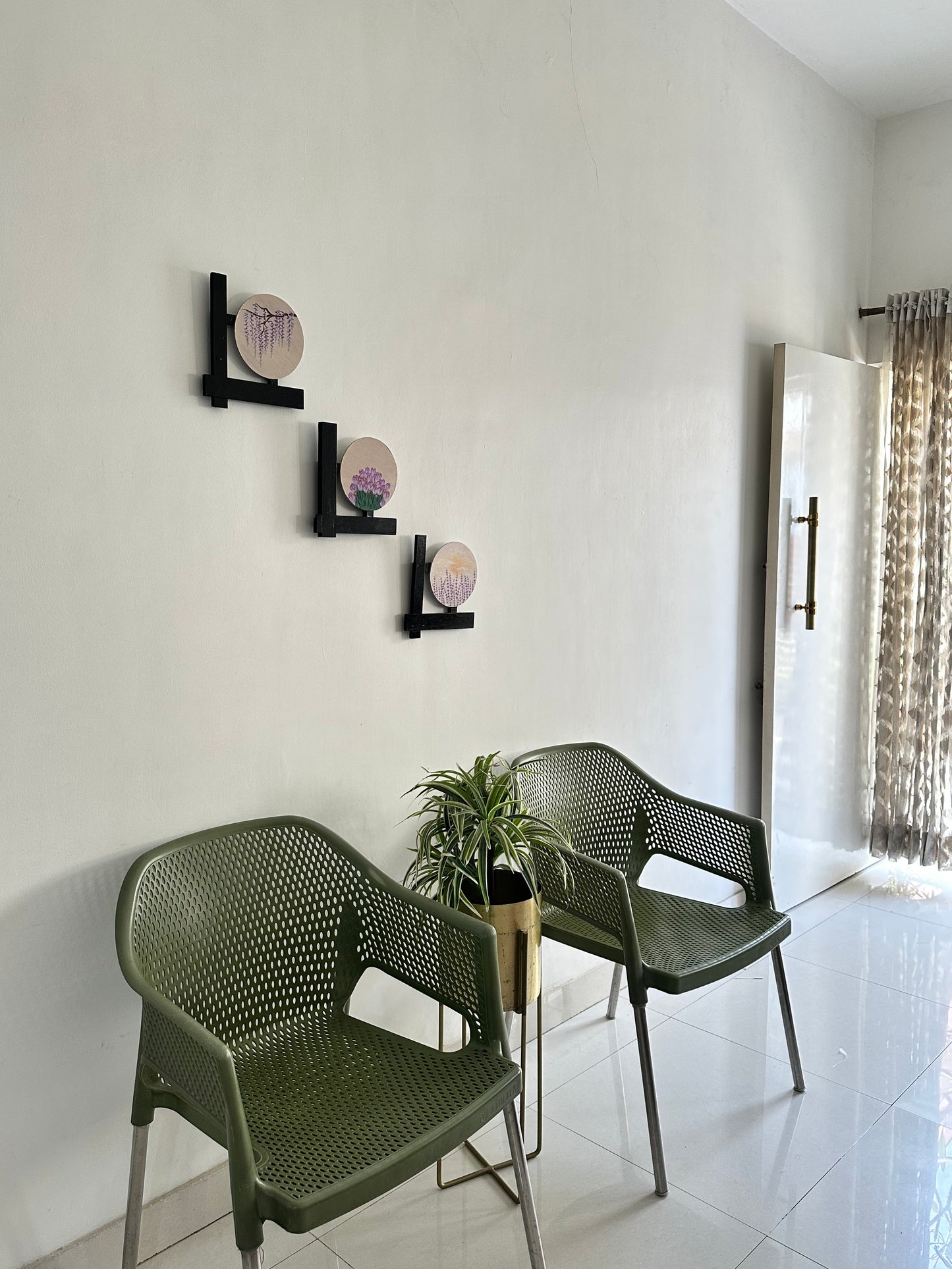 Set of 3 Floral wall hangings: Paintings on round MDF boards with black wooden L-shaped frames.