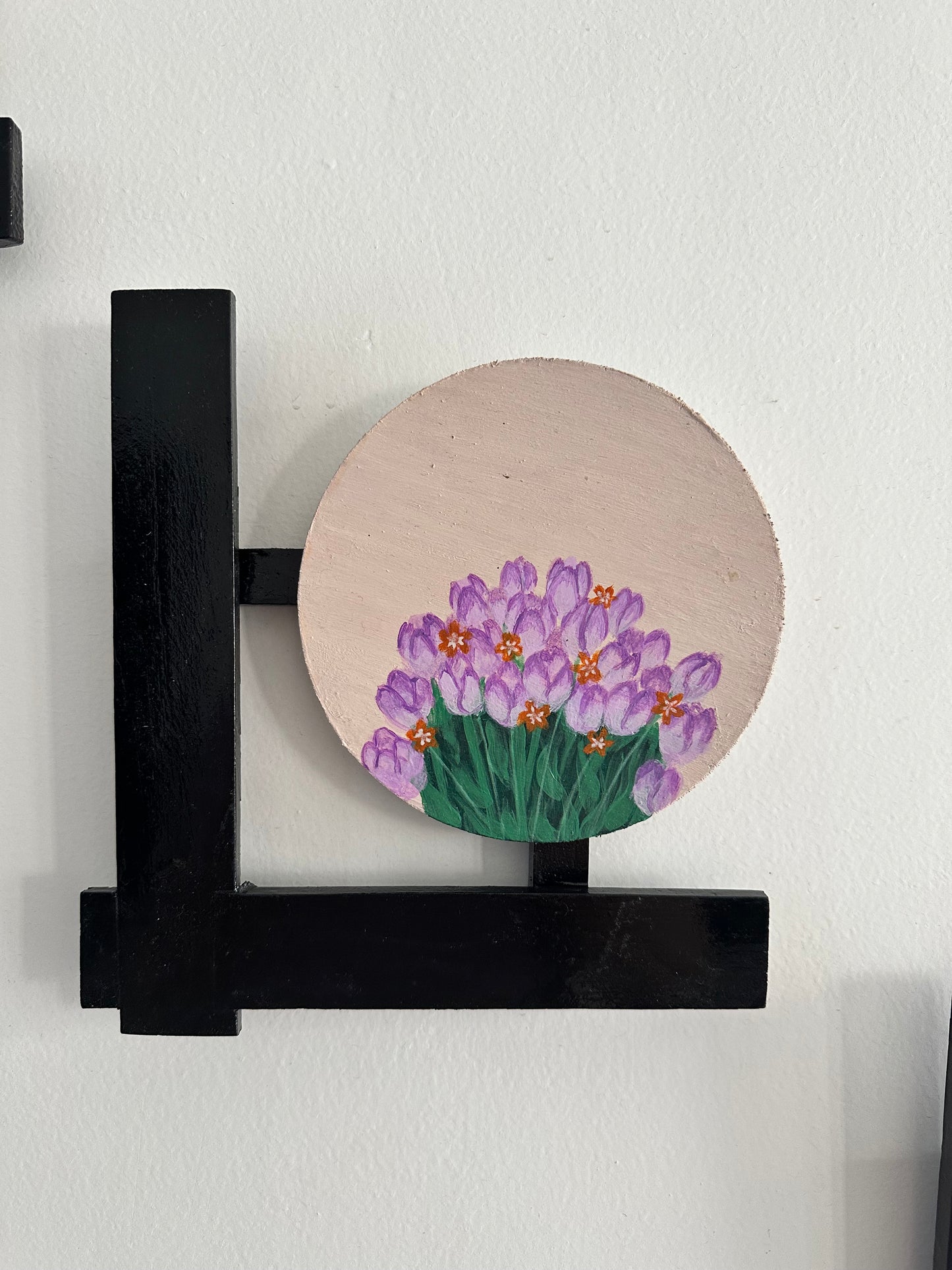 Set of 3 Floral wall hangings: Paintings on round MDF boards with black wooden L-shaped frames.