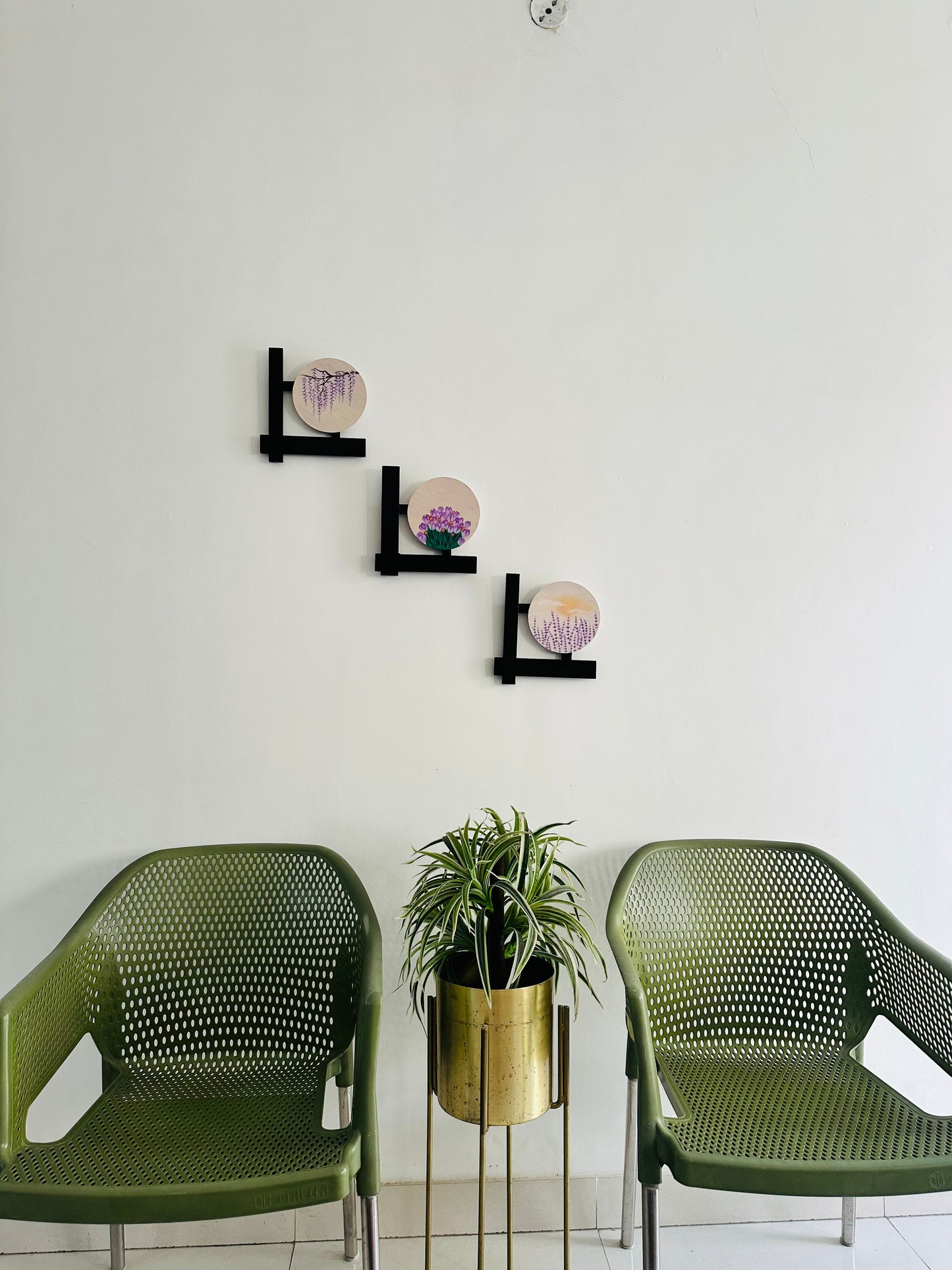 Set of 3 Floral wall hangings: Paintings on round MDF boards with black wooden L-shaped frames.