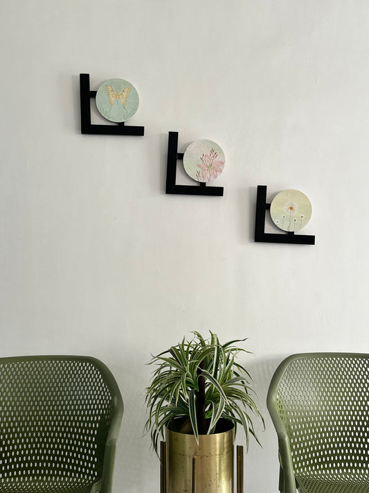 Set of 3 Floral wall hangings: Flat and Embossed Paintings on round MDF boards with black wooden L-shaped frames.